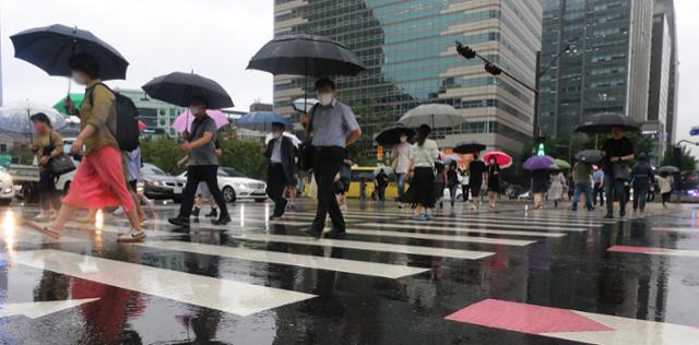 수도권에 호우 경보가 내린 지난달 30일 서울 광화문 네거리에서 우산을 쓴 시민들이 출근길을 재촉하고 있다. 뉴스1