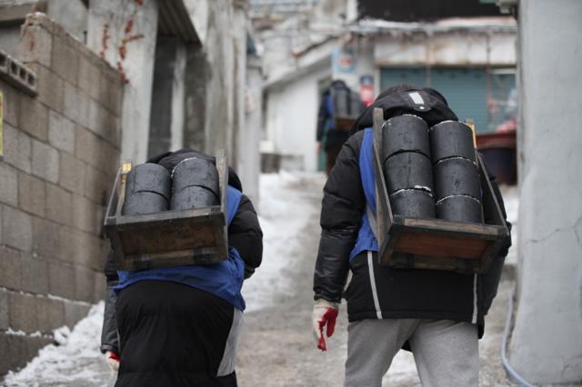 지난 1998년부터 소외된 이웃에 따뜻한 식사를 제공하는 등 봉사활동에 나선 밥상공동체가 올해로 창립 26년을 맞았다.지난 겨울 서울의 한 달동네를 찾은 자원봉사자들이 힘겹게 오르막길을 오르고 있다. 밥상공동체연탄은행 제공