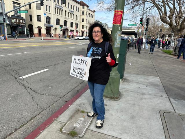 미국인 엘레나 모레티가 17일 미 캘리포니아주 오클랜드 시내에서 '머스크가 불법 점거 중이다. 지금 당장 제거하라'라고 적힌 팻말을 들고 있다. 민주당 지지자인 모레티는 "누구도 머스크에게 표를 주지 않았다"며 "머스크는 당장 정치 개입 시도를 멈춰야 한다"고 주장했다. 오클랜드=이서희 특파원