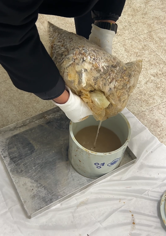 지난해 12월 국립영천호국원에서 의전단 직원이 유골함에 고인 물을 따라내고 있다. 국가보훈부 관계자 제공