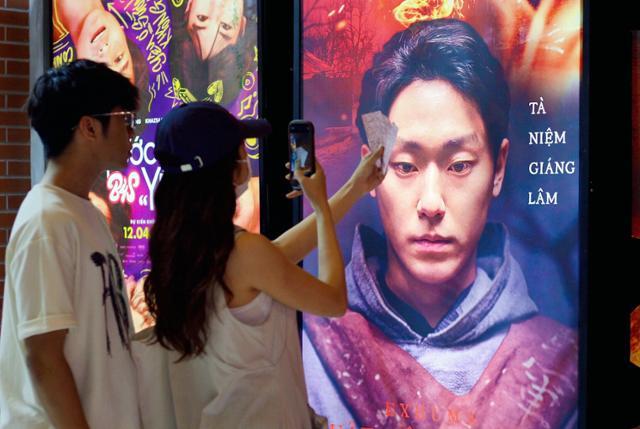 Vietnamese youth posing with 'Exhuma' movie poster.