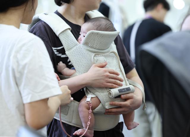 지난달 14일 서울 강남구 코엑스에서 열린 제48회 베페 베이비페어 관람객이 아기띠를 체험하는 모습. 뉴시스