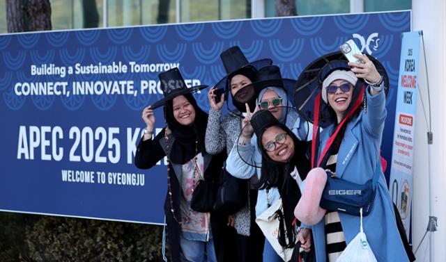 2025 경주 아시아태평양경제협력체(APEC) 정상회의 주간 첫날인 27일 외국인 관광객들이 경북 경주역에 설치된 환영부스에서 갓을 쓴 채 기념촬영을 하고 있다. 경주=뉴시스